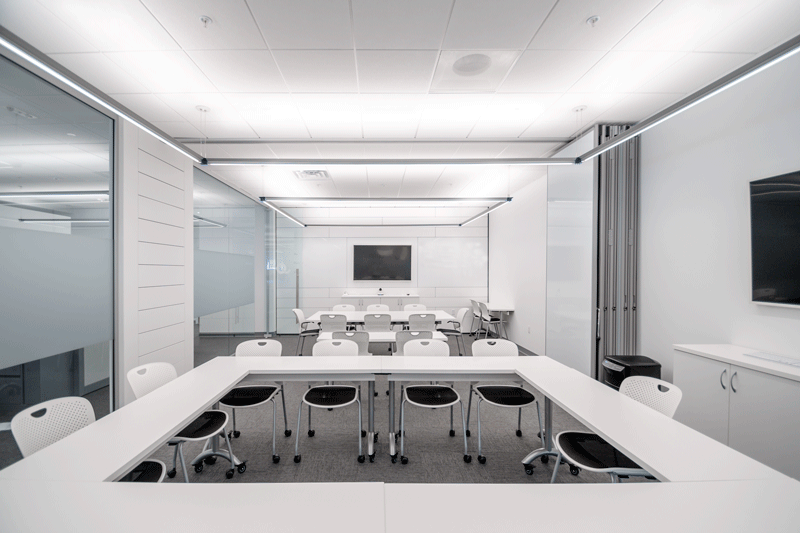 White office space with suspended led lights.